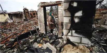  ?? (Zohra Bensemra\Reuters) ?? A WOMAN reacts as she examines the remains of her house, which was destroyed by Russian shelling during its invasion in Chernihiv this week.