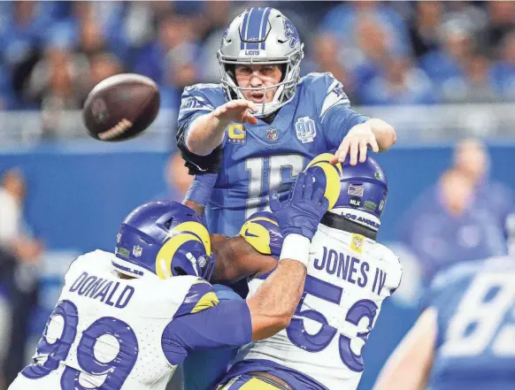  ?? JUNFU HAN/DETROIT FREE PRESS ?? Jared Goff makes a pass to Lions tight end Brock Wright as Rams defensive tackle Aaron Donald and linebacker Ernest Jones close in on the quarterbac­k during the first half Sunday.