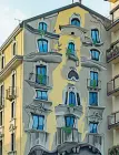  ?? ?? Street artist Cosimo Caiffa, alias Cheone, e a destra il palazzo da lui ridipinto a Milano