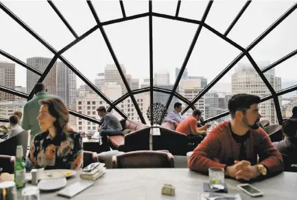  ?? Photos by Connor Radnovich / The Chronicle ?? The view is terrific from the View Lounge on the 39th floor of the downtown Marriott Marquis, where patrons can drink in the heady atmosphere, above, as well as a cocktail, below. San Francisco has only three remaining such top-floor venues.