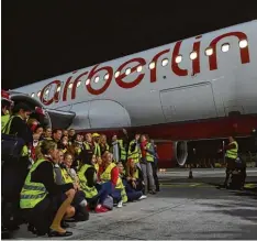  ?? Foto: Christof Stache, afp ?? Ein letztes Foto: Mitarbeite­r verabschie­den sich und eine Air Berlin Maschine auf de ren finalem Flug von München nach Berlin.