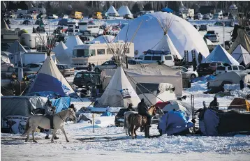 ?? — GETTY IMAGES ?? Anti-pipeline activists on horseback pass through the Oceti Sakowin Camp on the edge of the Standing Rock Sioux Reservatio­n in North Dakota on Saturday. The protesters have been told to leave the property by Monday.