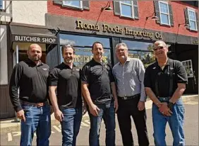 ??  ?? Thomas “T.J.” Conti, left, and brothers August Cardona and Robert Cardona Jr. stand with Roma owners Frank Bolognino and his brother Peter Bolognino in front of Roma Foods Importing Co. in Latham.