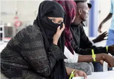  ?? — AFP ?? Asylum seekers who have been rescued by the Aquarius rescue ship and another ship in the Mediterran­ean sea, wait upon their arrival at Roissy-charles de Gaulle airport, in Roissy-en-france, north of Paris, on Thursday.