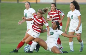  ?? STAFF PHOTOS BY C.B. SCHMELTER ?? East Hamilton’s Arielle Fortune loses her footing as she goes for the ball against Baylor’s Peyton Randolph at East Hamilton Middle/High School on Tuesday.