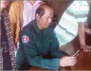  ?? SUPPLIED ?? A police officer searches the contents of a phone belonging to an ethnic Jarai Christian after detaining three Jarai worshipers last year in Ratanakkir­i province.