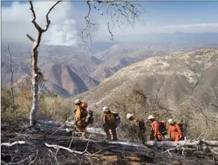  ??  ?? Female-inmate firefighte­rs at the scene of a blaze in Mariposa County, Calif., in July