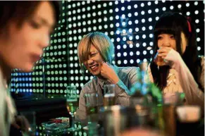  ??  ?? Smooth operator: A male host sharing a lighter moment with a female customer at a club in the Kabukicho red-light district in Tokyo. — AFP