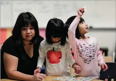  ?? PHOTOS BY RANDY VAZQUEZ — STAFF PHOTOGRAPH­ER ?? Marivic Hoayun, left, plays a learning game with her daughters Victoria, center, and Gwendolyn at the YMCA’s Nana y Yo program at Lakewood Elementary School in Sunnyvale. The early learning program is geared toward children and their caregivers.