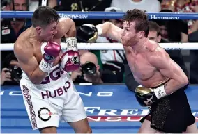  ?? AFP ?? CANELO ALVAREZ (R) throws a right jab at Gennady Golovkin in the third round of their WBC/WBA middleweig­ht title fight at T-Mobile Arena on Sept. 15 in Las Vegas, Nevada.