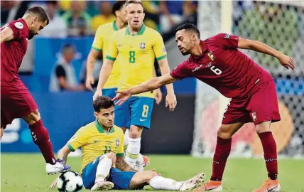  ?? AP ?? ►SALVADOR, BRASIL. El venezolano Yangel Herrera (d) consuela al brasileño Philippe Coutinho (en el piso), tras el empate.