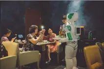  ?? YUYANG LIU / THE NEW YORK TIMES ?? Diners take pictures of a robotic waiter at Robot Magic Restaurant in Shanghai. While the robot has proved good from a marketing standpoint, a regular human waiter has to step in to actually deliver food to the restaurant’s customers.