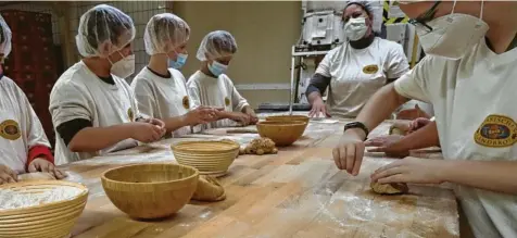  ?? Fotos: Philipp Brandstädt­er, dpa ?? Schulkinde­r lernen in einer Bäckerei, wie aufwendig Brotbacken ist. Sie üben sich an Sauerteig.
