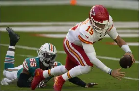  ?? LYNNE SLADKY - THE ASSOCIATED PRESS ?? Kansas City Chiefs quarterbac­k Patrick Mahomes (15) falls on the field after he was sacked by Miami Dolphins outside linebacker Jerome Baker (55), during the first half of an NFL football game, Sunday, Dec. 13, 2020, in Miami Gardens, Fla.