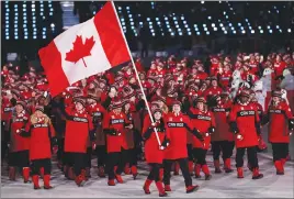  ?? Associated Press photo ?? Tessa Virtue and Scott Moir lead Team Canada into the stadium during the opening ceremony of the 2018 Winter Olympics in Pyeongchan­g, South Korea on Friday.