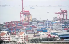  ??  ?? Containers sit stacked next to gantry cranes at the Sihanoukvi­lle Autonomous Port.