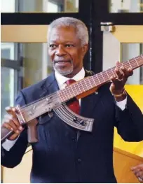  ??  ?? Kofi Annan shows an AK-47 assault rifle that has been transforme­d into a guitar.