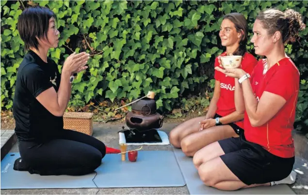  ??  ?? Mayuko Fujiki, la selecciona­dora de natación artística nacida en Japón, le enseña la ceremonia del té a Cecilia y Abril, dos chicas del equipo nacional en Sant Cugat, en Barcelona.