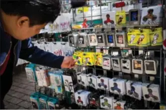  ?? MICHAEL NAGLE / BLOOMBERG FILE ?? A shopper browses fidget spinners displayed for sale by a street vendor in New York.