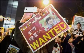  ?? — AFP ?? Speaking out: A protester holding up a wanted board with a photo of Akie during an anti-Abe demonstrat­ion near the prime minister’s official residence in Tokyo.