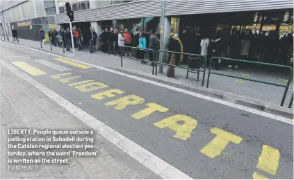  ?? Picture: AFP ?? LIBERTY. People queue outside a polling station in Sabadell during the Catalan regional election yesterday, where the word ‘Freedom’ is written on the street.