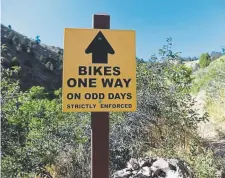  ?? Andy Cross, The Denver Post ?? A sign stating the mountain bikers must obey the one-way direction and only ride on odd days along the Apex trail in Apex Park.