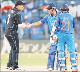  ?? REUTERS/Amit Dave. ?? India’s Mahendra Singh Dhoni (C) shakes hands with New Zealand’s Ross Taylor as Dinesh Karthik looks on after India won the match.