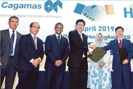  ?? PIC BY ROSELA ISMAIL ?? Cagamas Bhd president and chief executive officer (CEO) Datuk Chung Chee Leong (third from right) exchanging documents with Korean Housing Finance Corp CEO Lee Junghwan at the ‘Constructi­ng and Financing Affordable Housing Across Asia’ conference yesterday, witnessed by Housing and Local Government Minister Zuraida Kamaruddin (second from right). With them are (from left) Cagamas senior president (business and product developmen­t) Azizi Ali, Cagamas chairman Bakarudin Ishak and Bank Negara Malaysia deputy governor Abdul Rasheed Ghaffour.