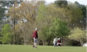  ?? (Photo by Neil Abeles) ?? ABOVE: Golfing on a Sunday afternoon in March at the Indian Hills Golf Club in Atlanta is just the thing for sport and family time. That’s what R J. Welborn is finding out with his son Jace as they line up the golf ball. Rodney Bynum is looking on at left.