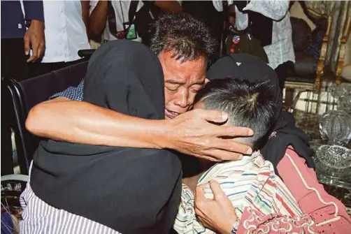 ?? PIC BY YAZIT RAZALI ?? Tayudin Anjut hugging his wife and two children at Prime Minister Datuk Seri Najib Razak’s residence in Kuala Lumpur yesterday.