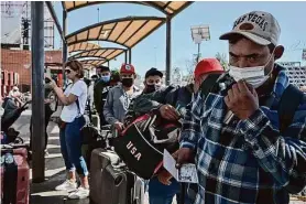  ?? Carlos A. Moreno/Special to The Chronicle 2022 ?? A group of Mexican agricultur­al visa workers waits to cross into the San Ysidro Port of Entry in Tijuana in March 2022. Gov. Gavin Newsom says the state can no longer contribute to the costs of testing migrants and issuing vaccines.