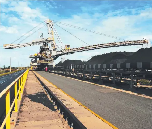  ?? Picture: BLOOMBERG NEWS ?? EXPORT BOOST: A spreader distribute­s coal at Mackay Harbor as an update from the Department of Industry shows overseas shipments of Australian coal will earn the country $58.1 billion this financial year.