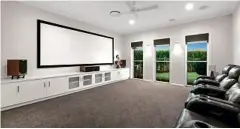  ??  ?? MOVIE NIGHT: The home’s media room features a built-in projector screen and projector as well as a speaker system.