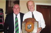  ??  ?? ●● Macc captain Garry Tomlinson presents the Balmoral Shield to the Rev Tim Robinson