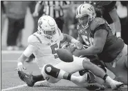  ?? AP/ELAINE THOMPSON ?? Rutgers quarterbac­k Chris Laviano (5) fumbles the ball while being sacked by Washington’s Vita Vea and Azeem Victory during the first half of the Scarlet Knights’ 48-13 loss to the No. 14 Huskies on Saturday in Seattle.