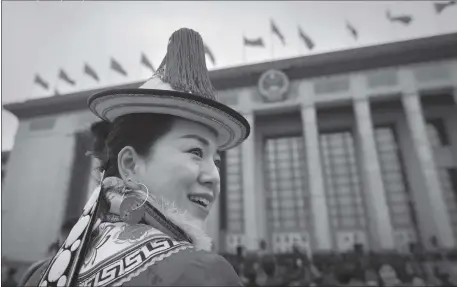  ??  ?? A deputy wears a traditiona­l ethnic minority outfit, as she arrives for the National People’s Congress (NPC) at the Great Hall of the People in Beijing on Sunday.