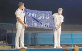  ?? STACY GODFREY/U.S. NAVAL ACADEMY ?? 1st Class Midshipman Quinn O’Loane and 1st Class Midshipman Ryan Chapman present former Secretary of Defense and retired Marine Corps Gen. Jim Mattis a “Don’t Give Up The Ship” flag.