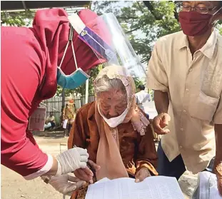  ?? DIMAS NUR APRIYANTO/JAWA POS ?? DATANG SEJAK PAGI: Mbah Munsini, salah seorang penerima BLT dari pemprov, didampingi cucunya saat pengambila­n di Bank Jatim Universita­s Wijaya Kusuma kemarin (26/5).