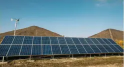  ??  ?? PAS-DE-CALAIS, France : A picture shows a wind turbine and solar panels installed at the Lumiwatt site, a site of research and testing on photovolta­ic panels. — AFP