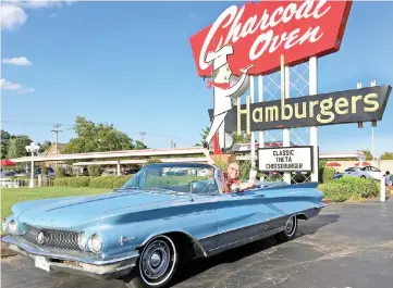  ??  ?? In a 1960 Buick Electra, self-proclaimed “Ambassador of Americana” Charles Phoenix rolls up on the Charcoal Oven, a 56-year-old classic Oklahoma City hamburger stand, on its last day of business.