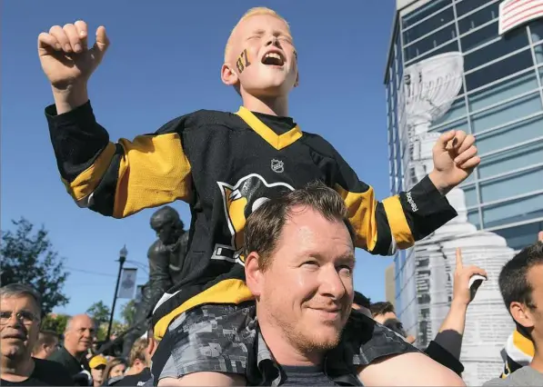  ??  ?? Before the Penguins played the San Jose Sharks on Monday, 10-year-old George Coyle of Washington, Pa., cheered from atop his dad Sean’s shoulders.