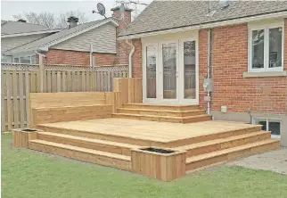  ??  ?? A cedar deck, complete with built-in bench and planters, provides an inviting spot for backyard gatherings.