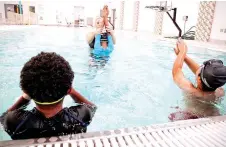  ?? — AFP photos ?? Photos show Bergstrom holding a free swimming lesson with students of Bishop John T. Walker School for Boys at Ferebee-Hope Aquatic Center in Washington, DC.