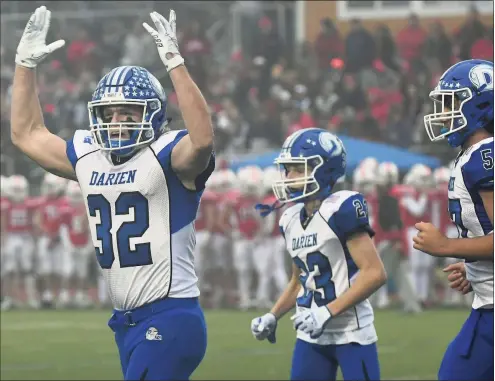  ?? Erik Trautmann / Hearst Connecticu­t Media ?? Darien players celebrat during the Class LL state championsh­ip football game againsst Fairfield Prep on Saturday in Trumbull.