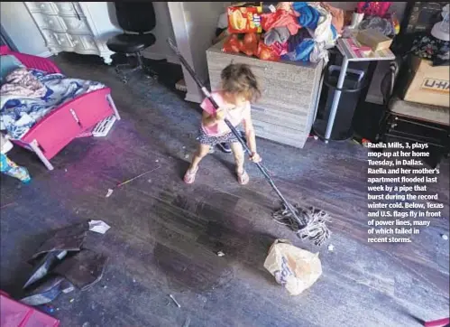  ??  ?? Raella Mills, 3, plays mop-up at her home Tuesday, in Dallas. Raella and her mother’s apartment flooded last week by a pipe that burst during the record winter cold. Below, Texas and U.S. flags fly in front of power lines, many of which failed in recent storms.