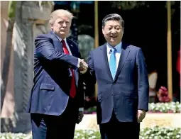  ??  ?? U.S. President Donald Trump (L) and China's President Xi Jinping shake hands while walking. Pic Reuters