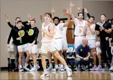  ?? Photo courtesy of JBU Sports Informatio­n ?? John Brown’s Payton Guiot runs back to play defense as his teammates celebrate after Guiot hit a 3-pointer during Tuesday’s game against Benedictin­e College.