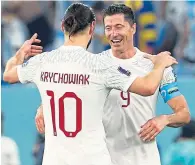  ?? ?? Robert Lewandowsk­i celebrates reaching the last 16 with team-mate Grzegorz Krychowiak