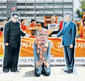  ??  ?? Kim Jong-un und Moon Jae-in steuern US-Präsident Donald Trump fern – das wollen Demonstran­ten in Seoul zu Ausdruck bringen.