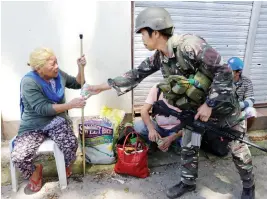  ??  ?? Filipino 62-year-old Linda receives water after being rescued from the combat zone where she and her family were trapped for more than 5 weeks pictured in Marawi city on Saturday. (Reuters)